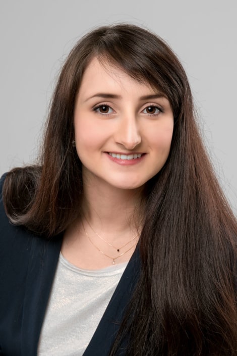 Bewerbungsfoto einer jungen Frau vor hellem Studiohintergrund