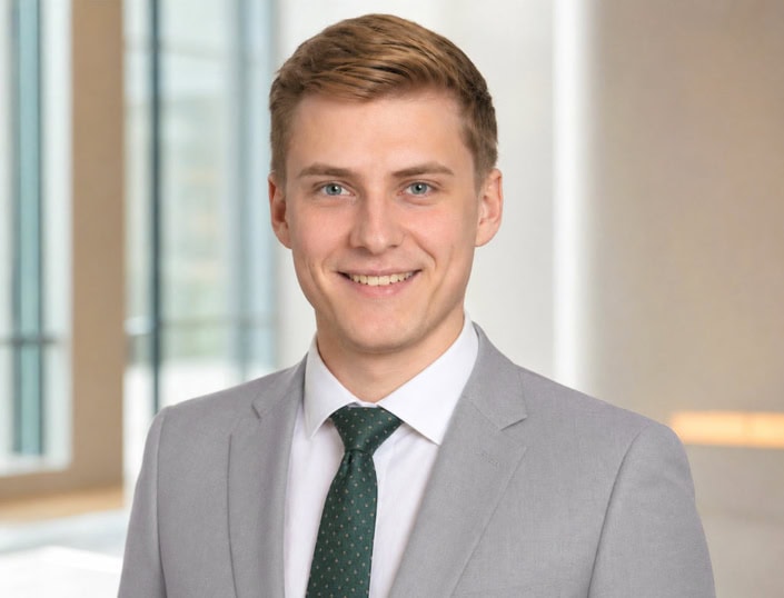 Bewerbungsfoto eines jungen Mannes im hellgrauen Anzug mit grüner Krawatte