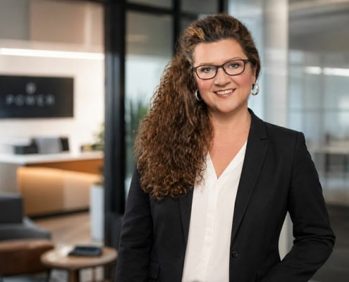 Businessporträt einer Frau mit lockigem Haar im dunklen Blazer