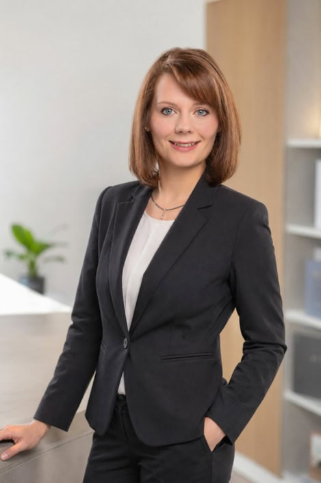 Professionelles Businessporträt einer Frau im dunklen Blazer in einem hellen Büro, fotografiert für beruflichen Auftritt, Firmenwebseite oder Businessprofil.