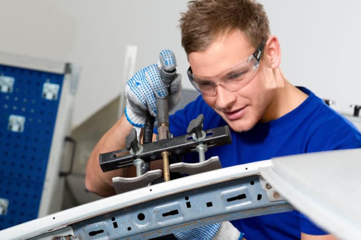 Techniker arbeitet konzentriert an einem Metallbauteil