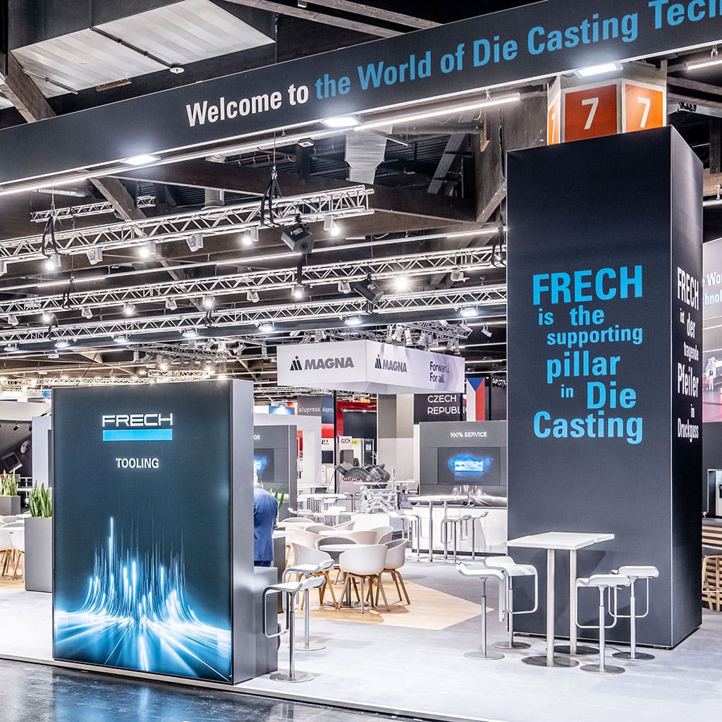 Moderner Messestand mit beleuchteten Präsentationsflächen in einer Messehalle.